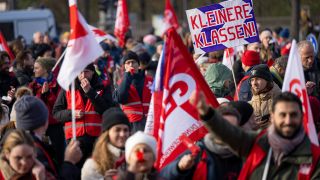 Ein Teilnehmer der Demonstration der Gewerkschaft Erziehung und Wissenschaft (GEW) hält am 25.11.2022 während der Kundgebung vor dem Brandenburger Tor ein Schild mit der Aufschrift „Kleinere Klassen“ hoch. (Quelle: dpa/Monika Skolimowska)