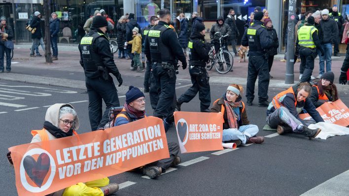 Mitglieder der Umwelt-Gruppe "Letzte Generation" blockieren die Straße am Potsdamer Platz. (Quelle: dpa/Paul Zinken)